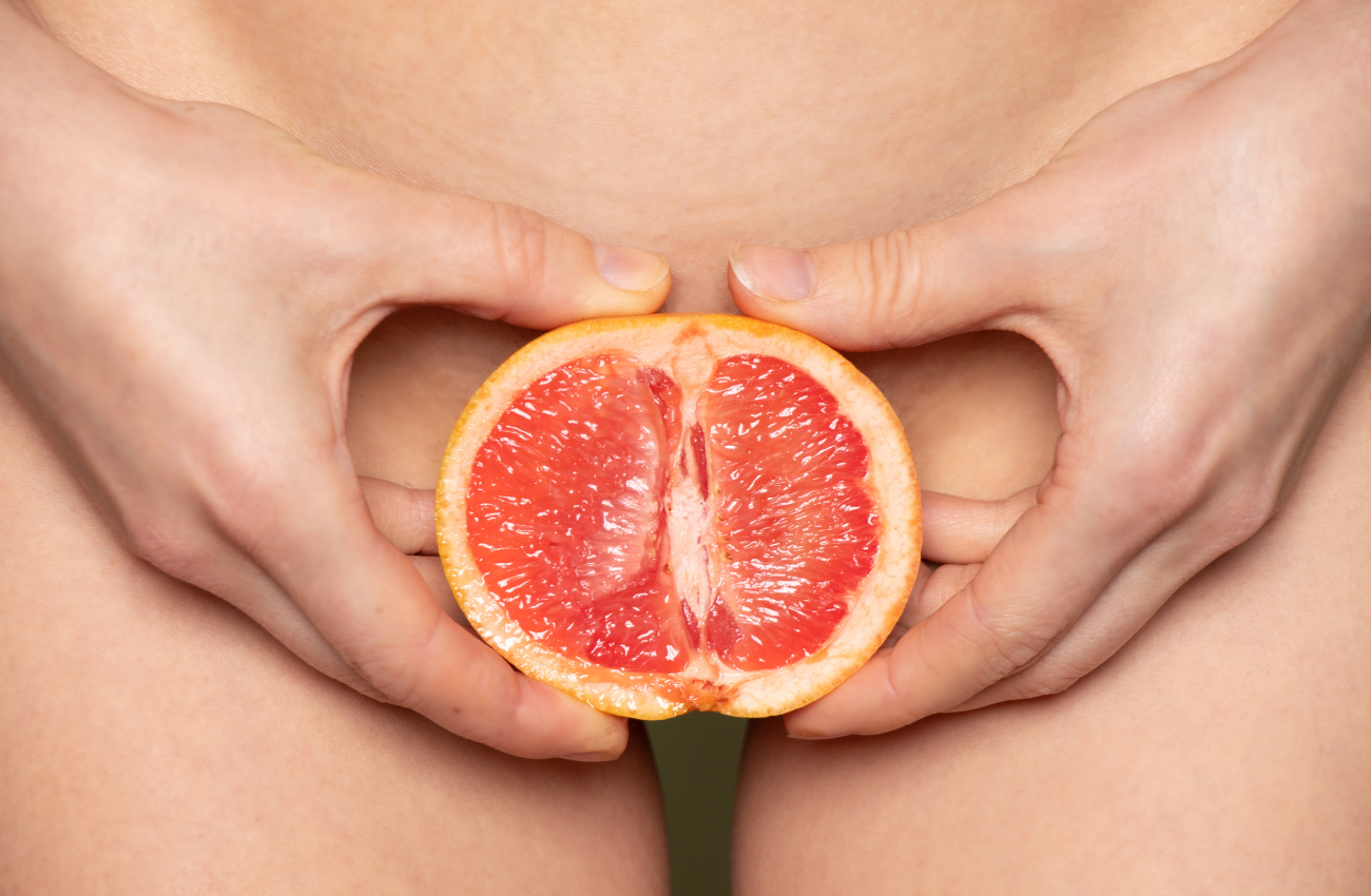 Woman holding grapefruit by vagina - The Clitoris Guide: Understanding Female Sexual Anatomy