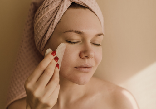 Woman-Using-Gua-Sha-Facial-The-Womens-Journal-Skincare-Beauty