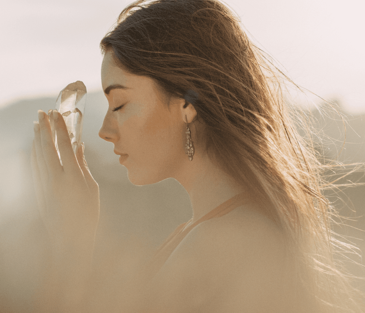 Woman Closing Eyes With Intentions Holding Clear Quartz Crystal 