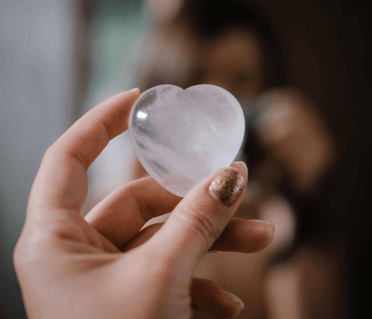 Crystal Therapy - Woman's Hand Holding Rose Quartz Crystal for Love and Self-Love 
