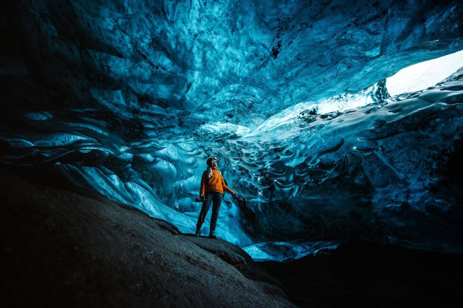 Woman Exploring Ice Cave In Iceland - Adventure Travel For Women