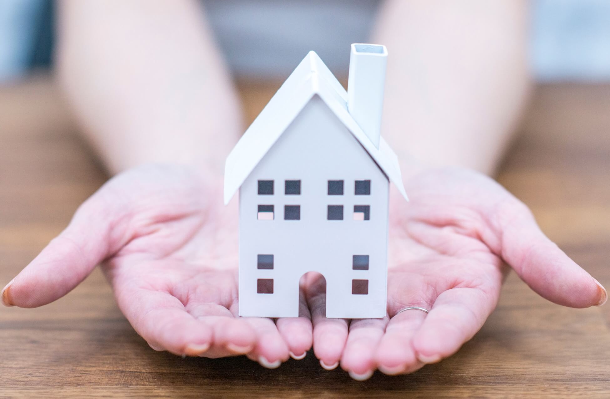 Woman Holding Toy House In Palm Of Hands - Gender Disparity First Time Buyers London