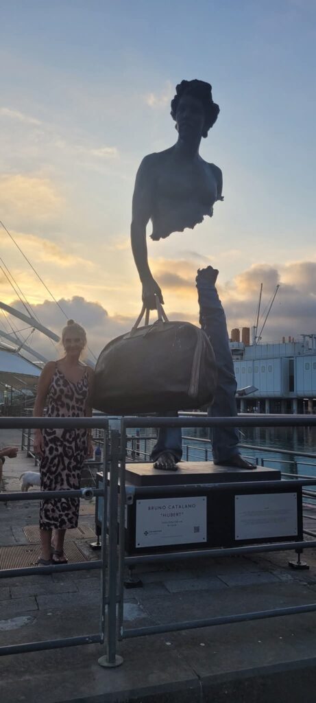 Alison Weihe standing beside Bruno Catalano’s 'Hubert' statue, symbolising travel, perspective, and personal transformation travelling in her 60s
