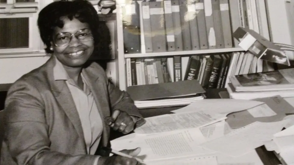 Dr. Gladys Mae West sat at her desk covered in files working in 1984