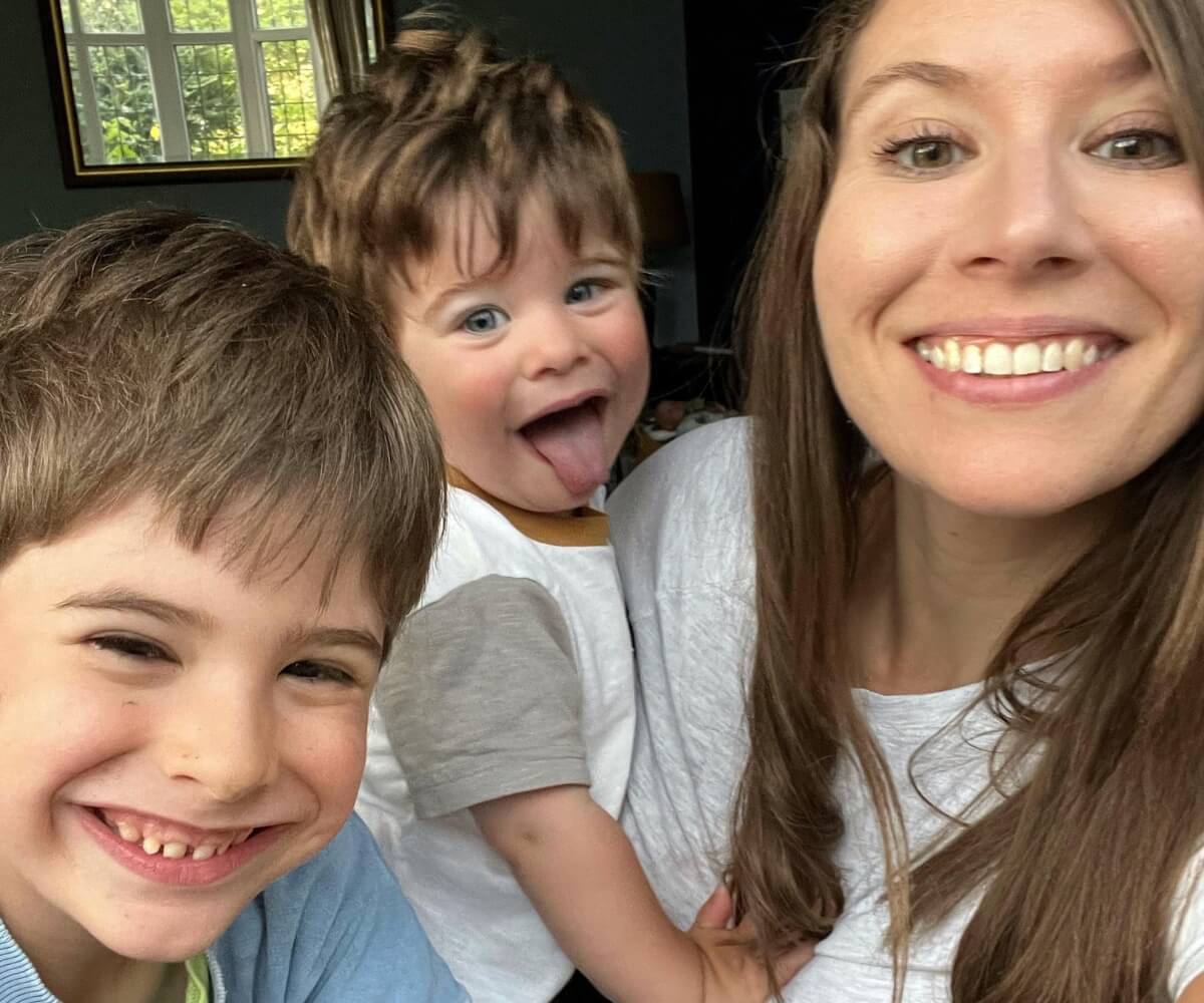 Danielle Wilkins, The Women's Journal journalist and boy mum, smiling at home with her two young sons in a mum and sons family selfie