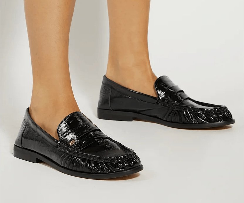 Close up of Dune Grisella Black Leather Slip On Ruched Toe Loafers worn by a model