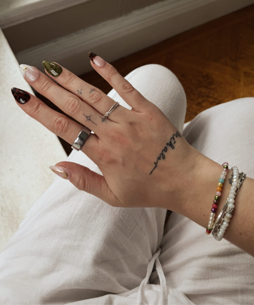 Almond-shaped spring nails with mix-and-match designs including marble, tortoiseshell tips, olive green polish and minimal nude accents