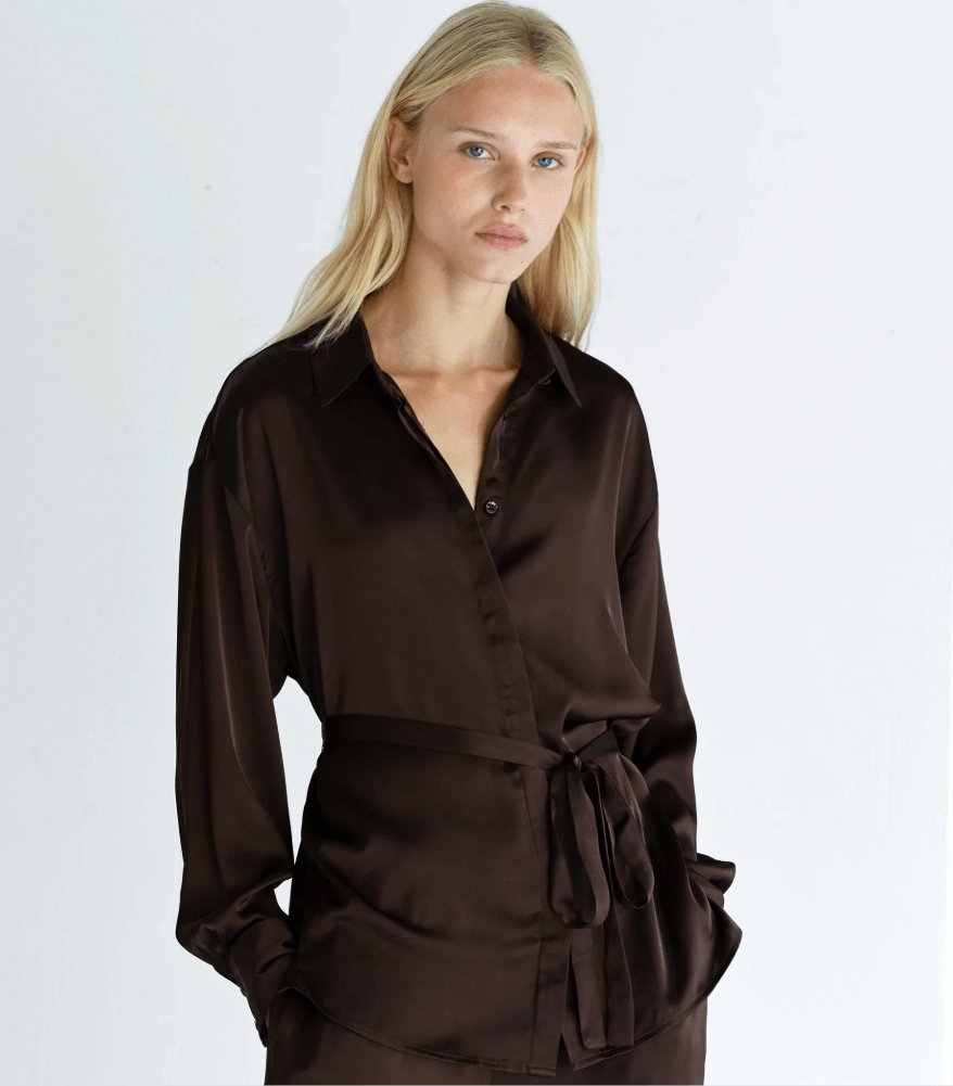 Model wearing French Connection Bernadetta satin tie belt shirt in bitter chocolate with long sleeves and a waist tie belt