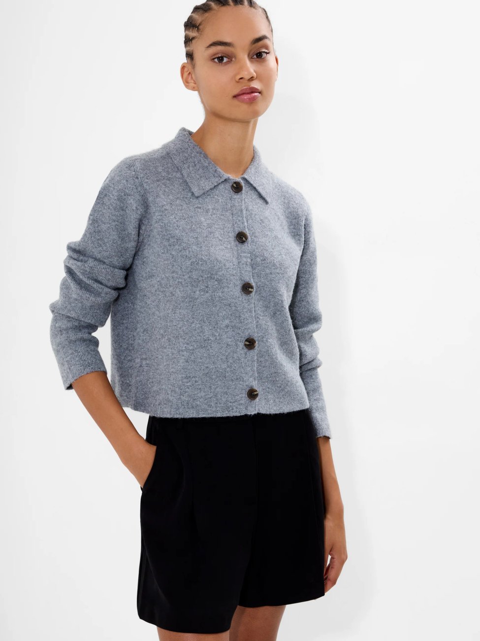 Model wearing French Connection Ellie Knit Collared Cardigan, a grey cropped cardigan with a collared neck paired with black shorts