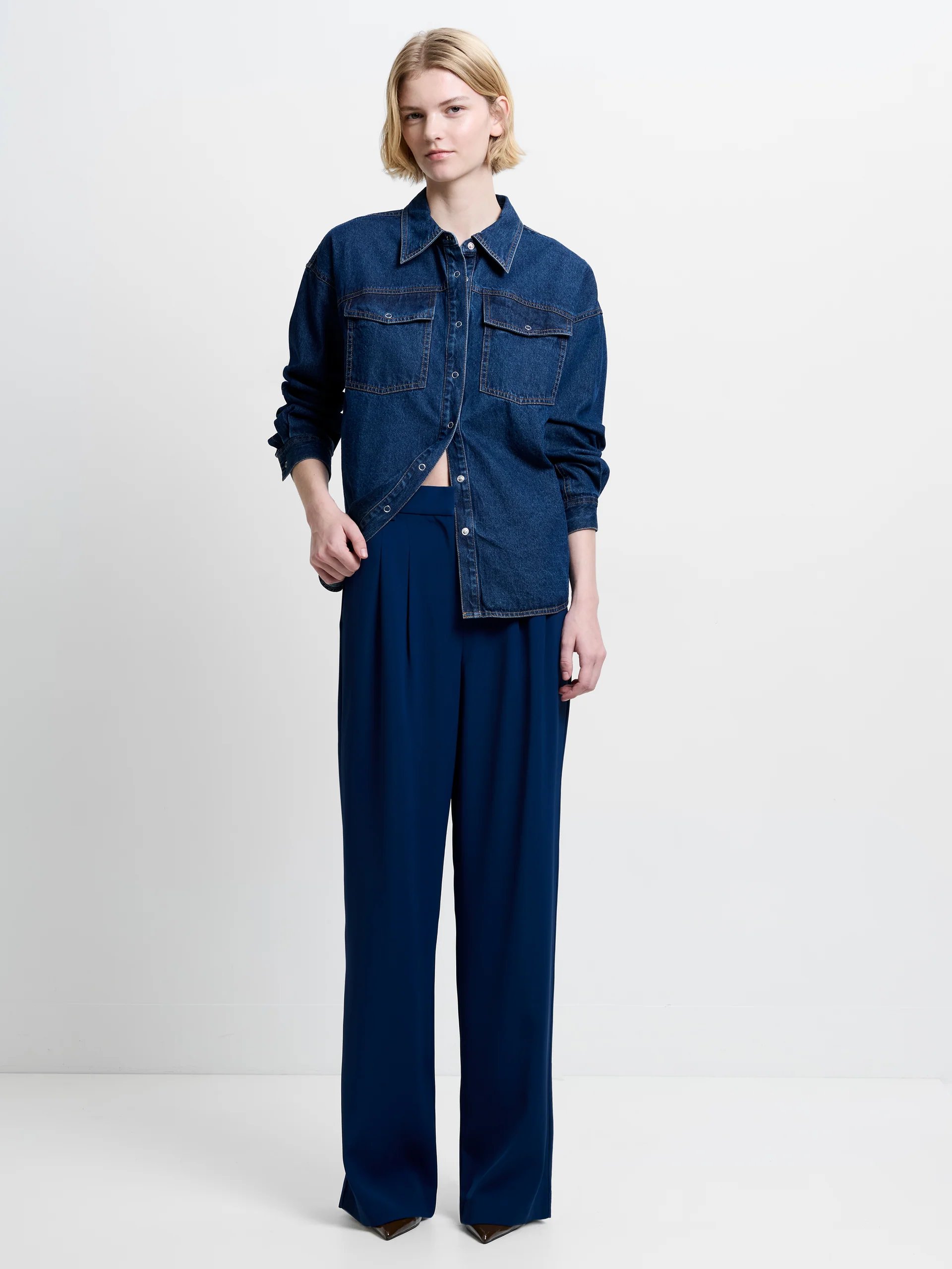 Model wearing French Connection Harrie Tailored Trousers in the colour midnight blue, one of the best pairs of tailored workwear trousers for women
