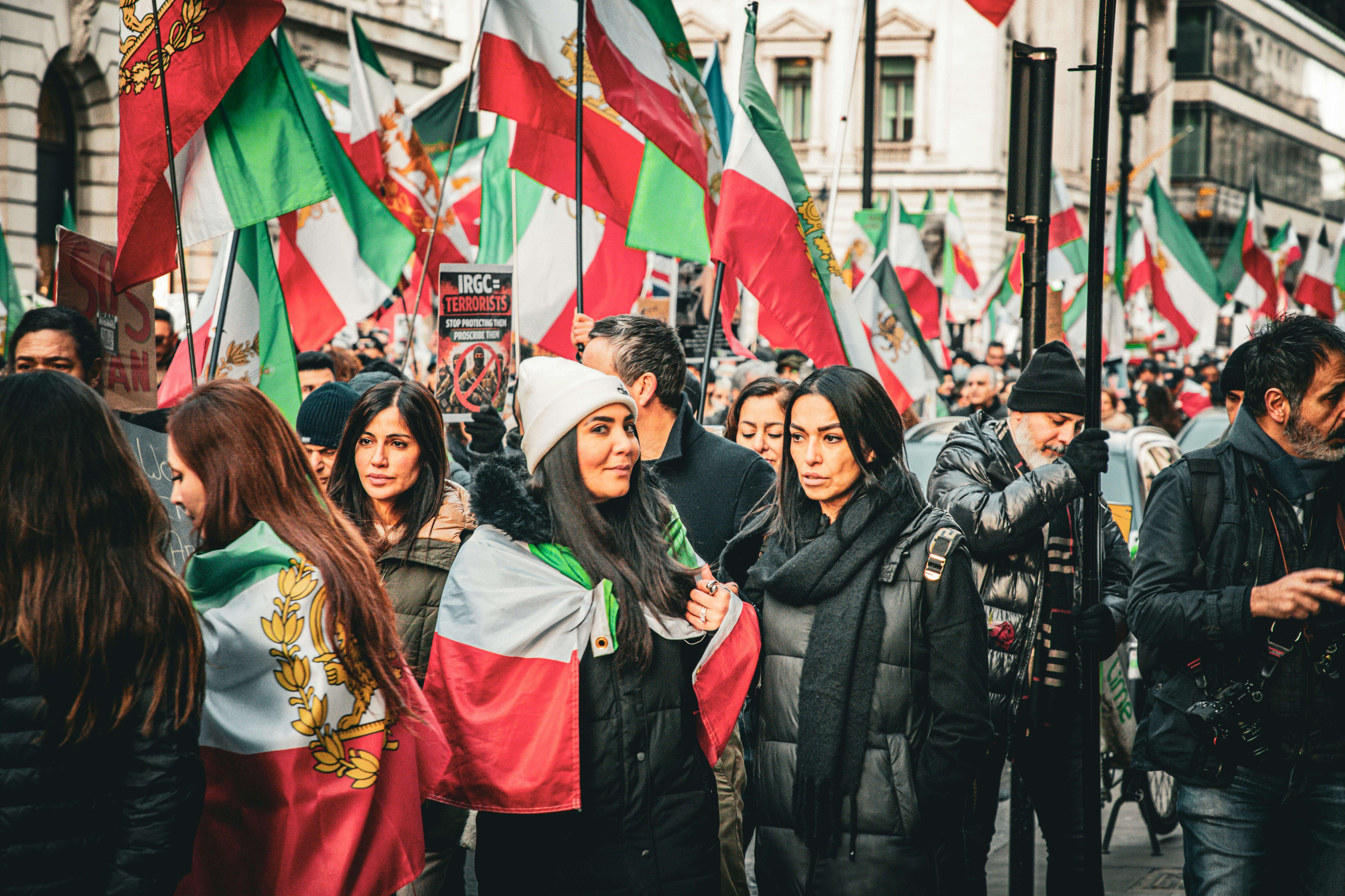 Women at an Iran protest in London holding Iranian flags during a solidarity demonstration for the Woman, Life, Freedom movement.