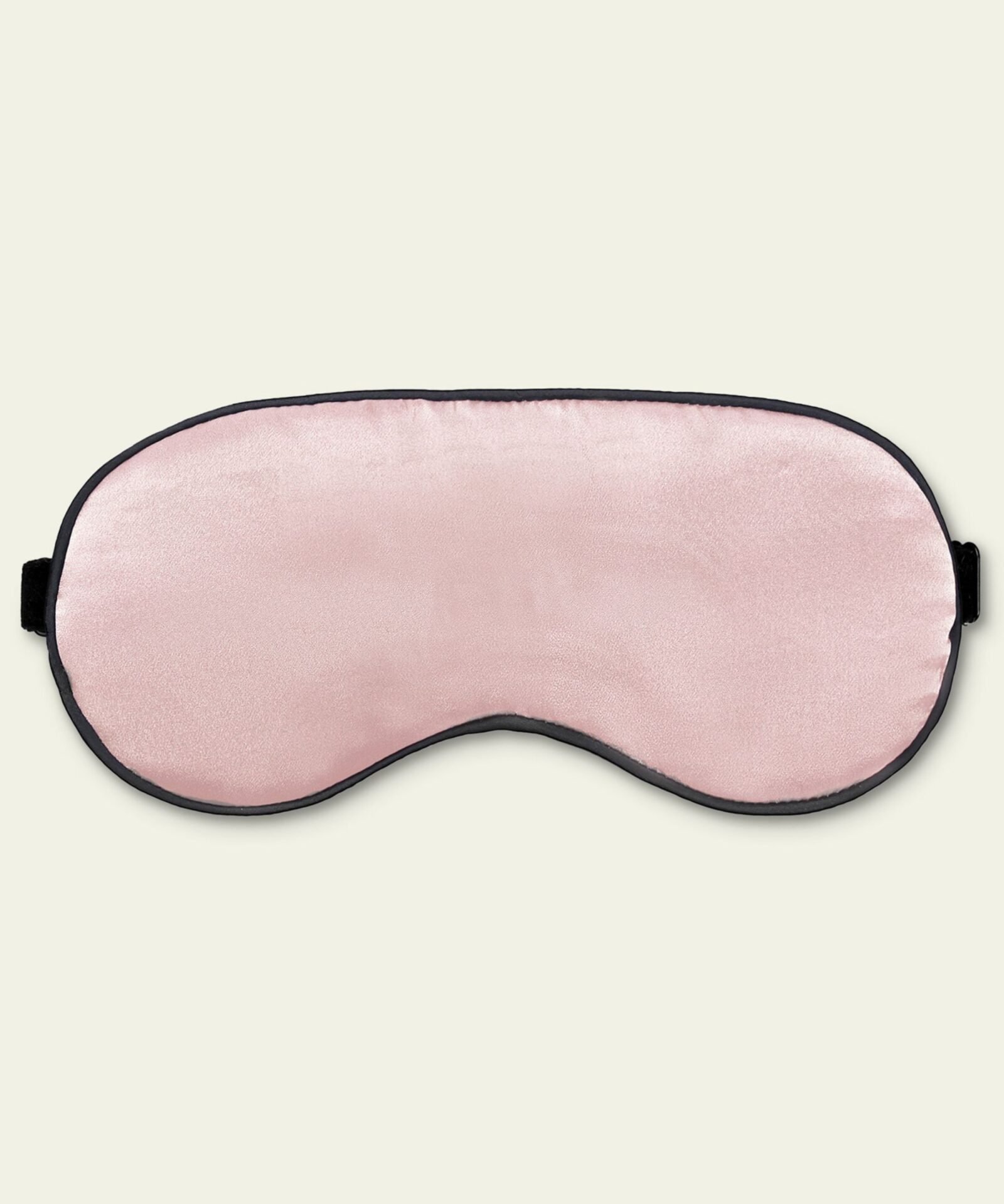 Pink LILYSILK silk sleep eye mask with black trim on a cream background