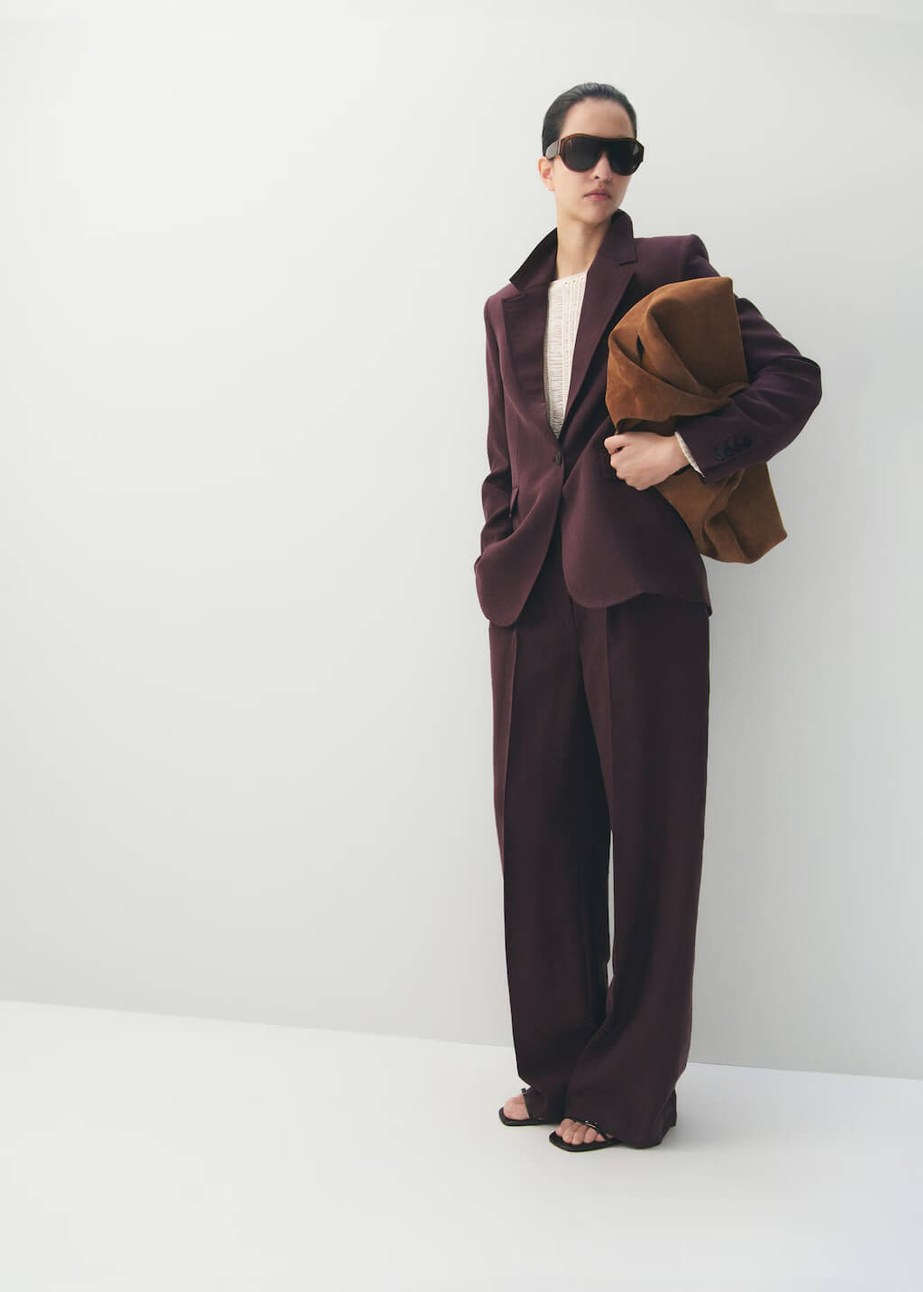 Model wearing a burgundy suit and sunglasses, showcasing Mango Lyocell low-rise trousers in purple