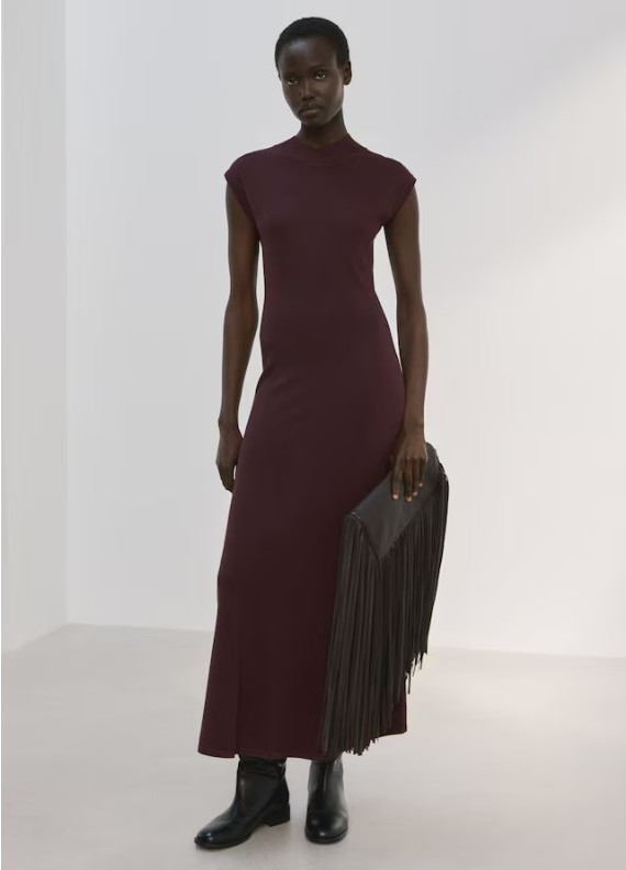 Model wearing Mango Perkins neck knitted dress in chocolate, a sleeveless, midi-length dress, paired with black shoes