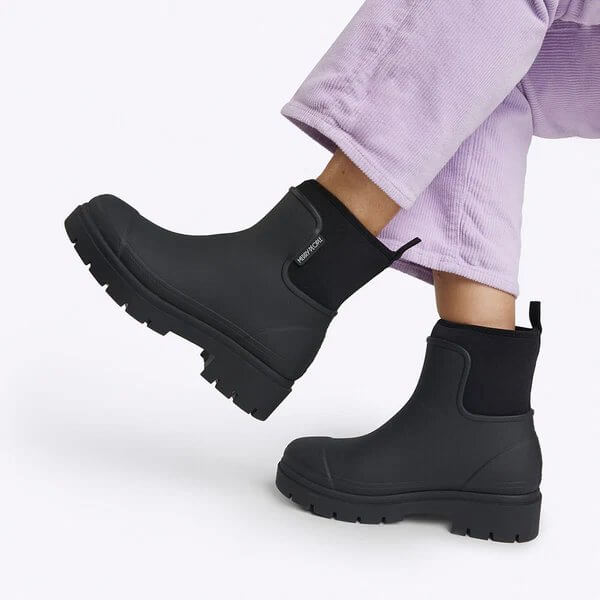 Merry People black ankle waterproof boots worn with purple corduroy pants