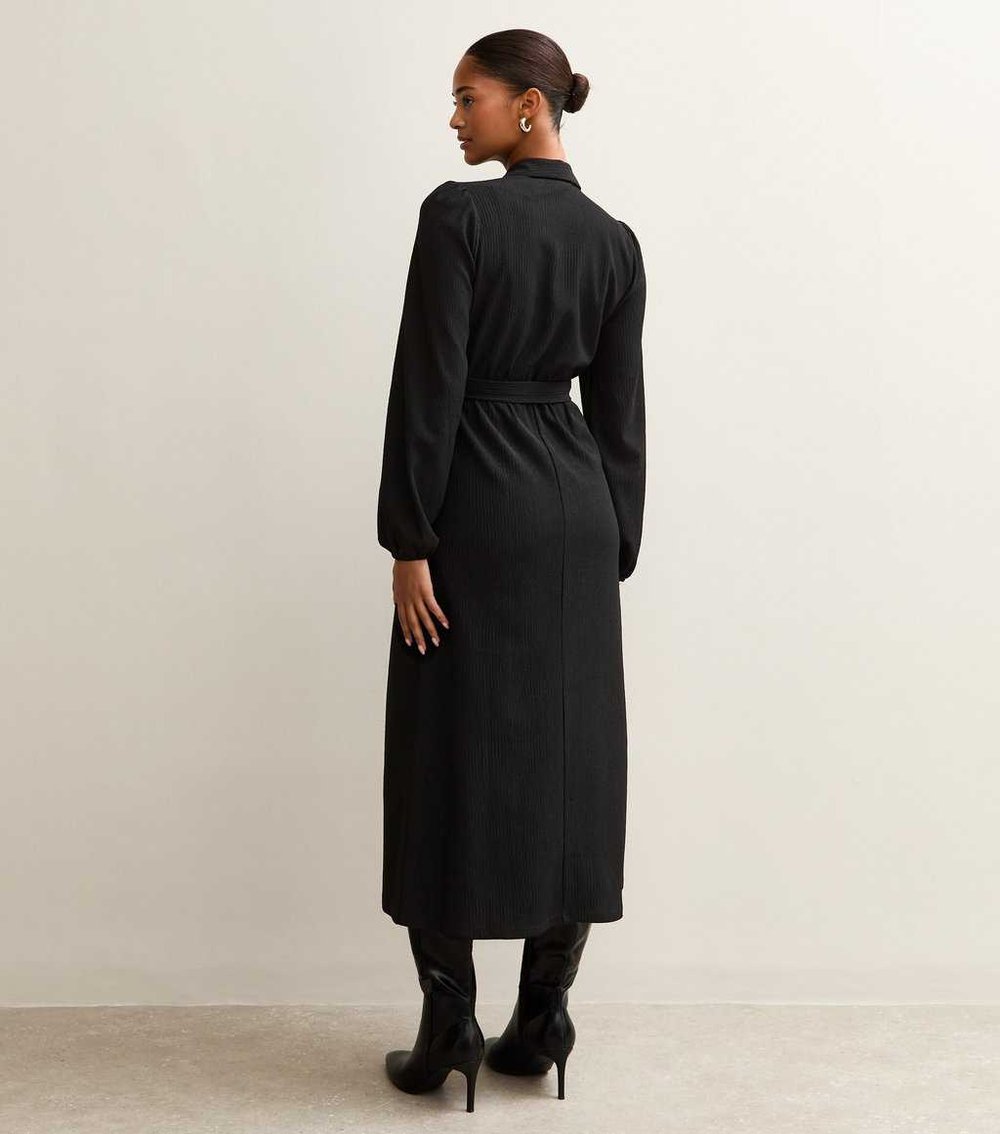 Back view of New Look black crinkled shirt dress with long sleeves, paired with high heel black boots