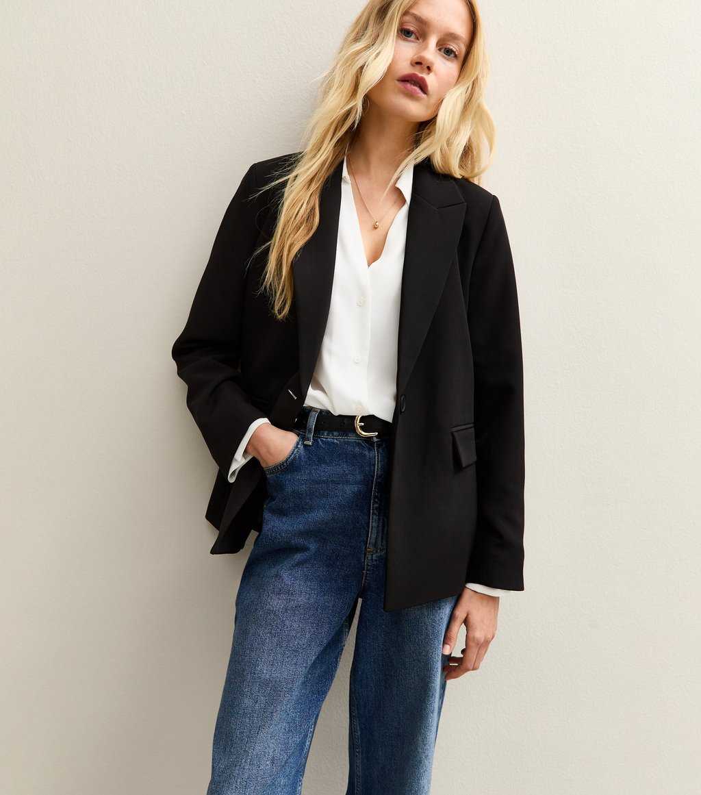 Model wearing New Look single-breasted black blazer over a white blouse and blue jeans