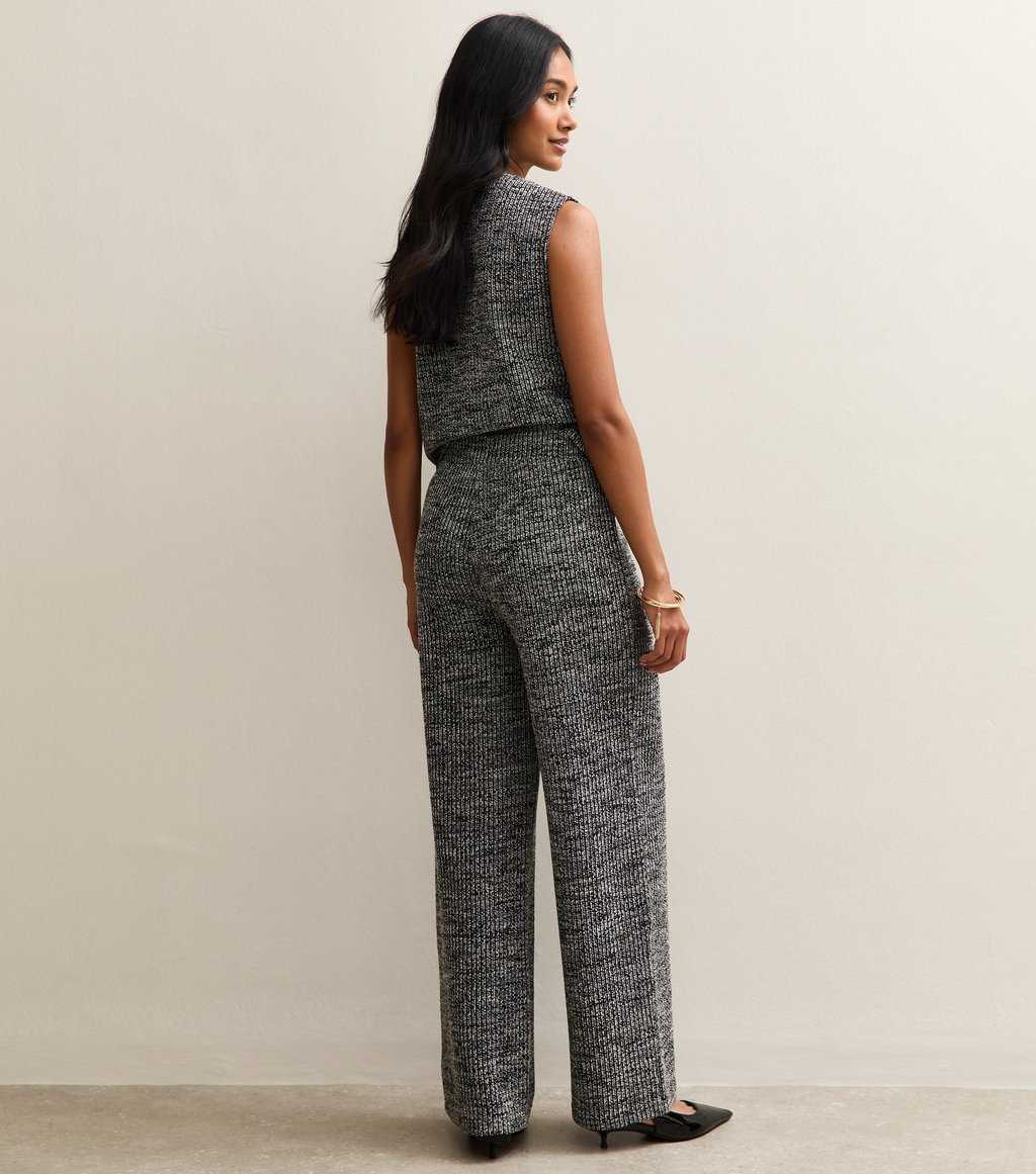 A back view of a model wearing New Look Black Soft Touch Ribbed Knit Wide Leg Trousers, soft workwear trousers for women