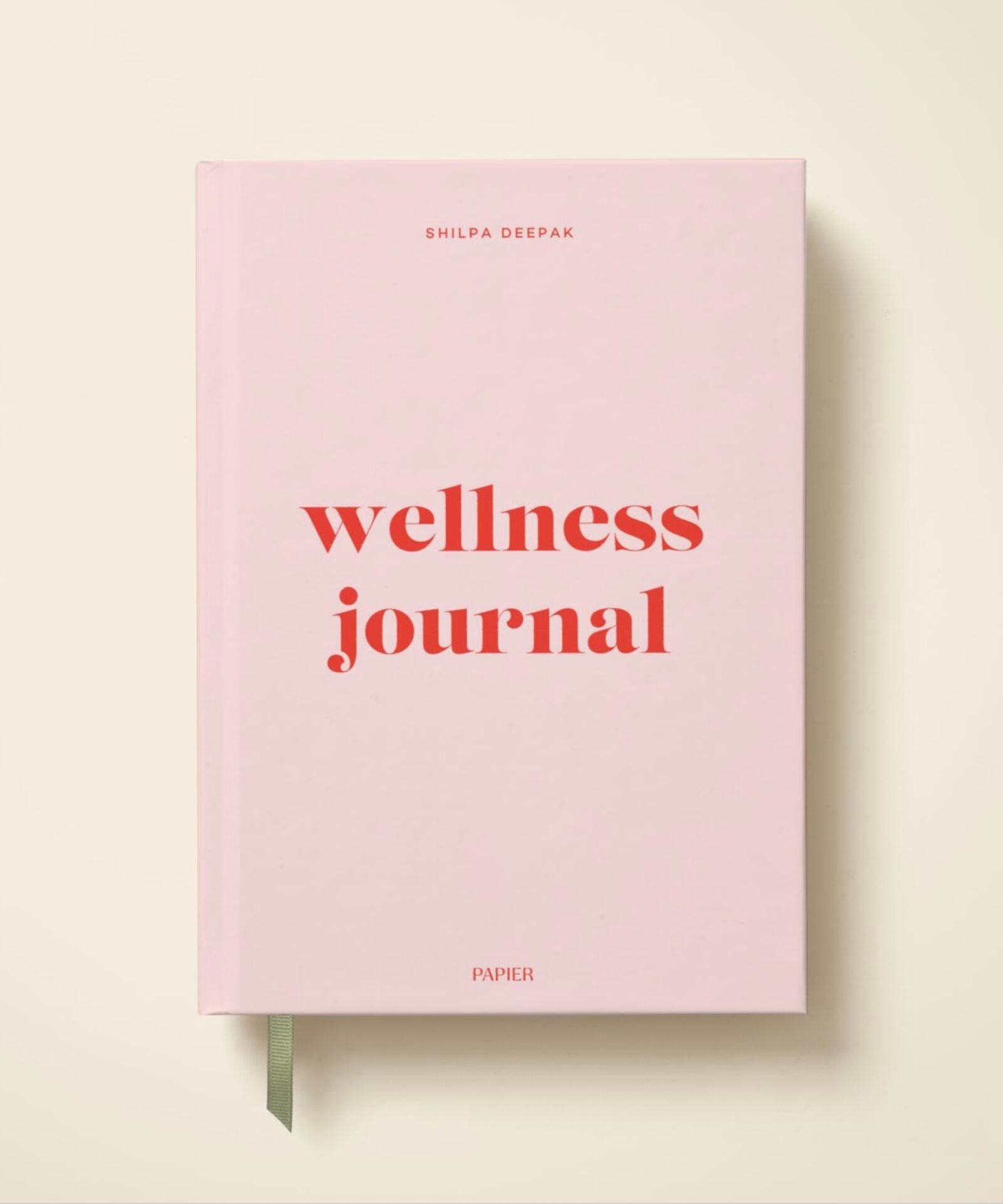 Pink Papier Wellness Journal by Shilpa Deepak on a cream background