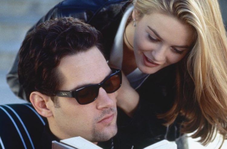 Paul Rudd as Josh, reading a book with his sunglasses on, while Alicia Silverstone as Cher leans onto his shoulder in a scene from 'Clueless'.