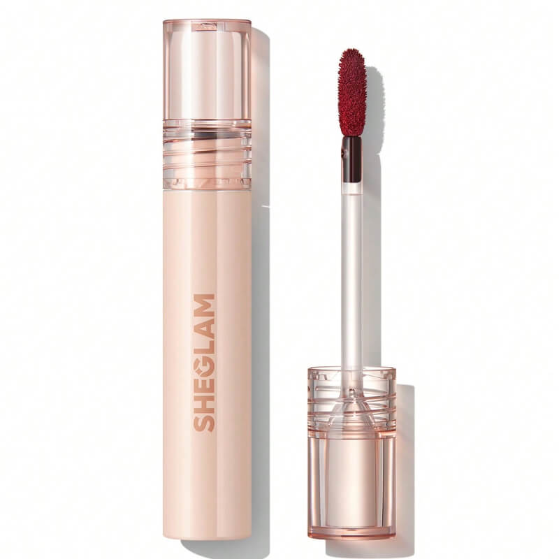 A SHEGLAM lip stain in a clear tube with a red applicator wand, showcasing a cherry-bark shade