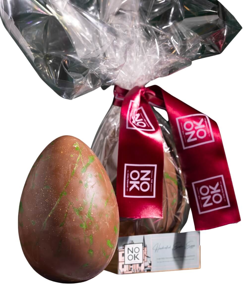 The Nook Cheltenham Midi chocolate Easter egg with green splatter design and red Nook ribbon packaging