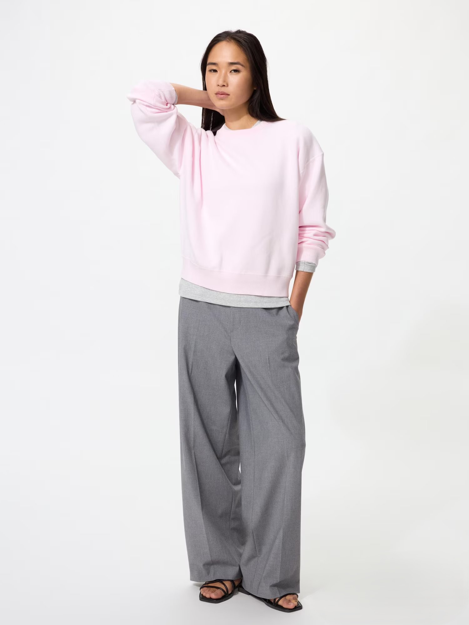 Model wearing Uniqlo smart wide trousers in grey with a light pink jumper