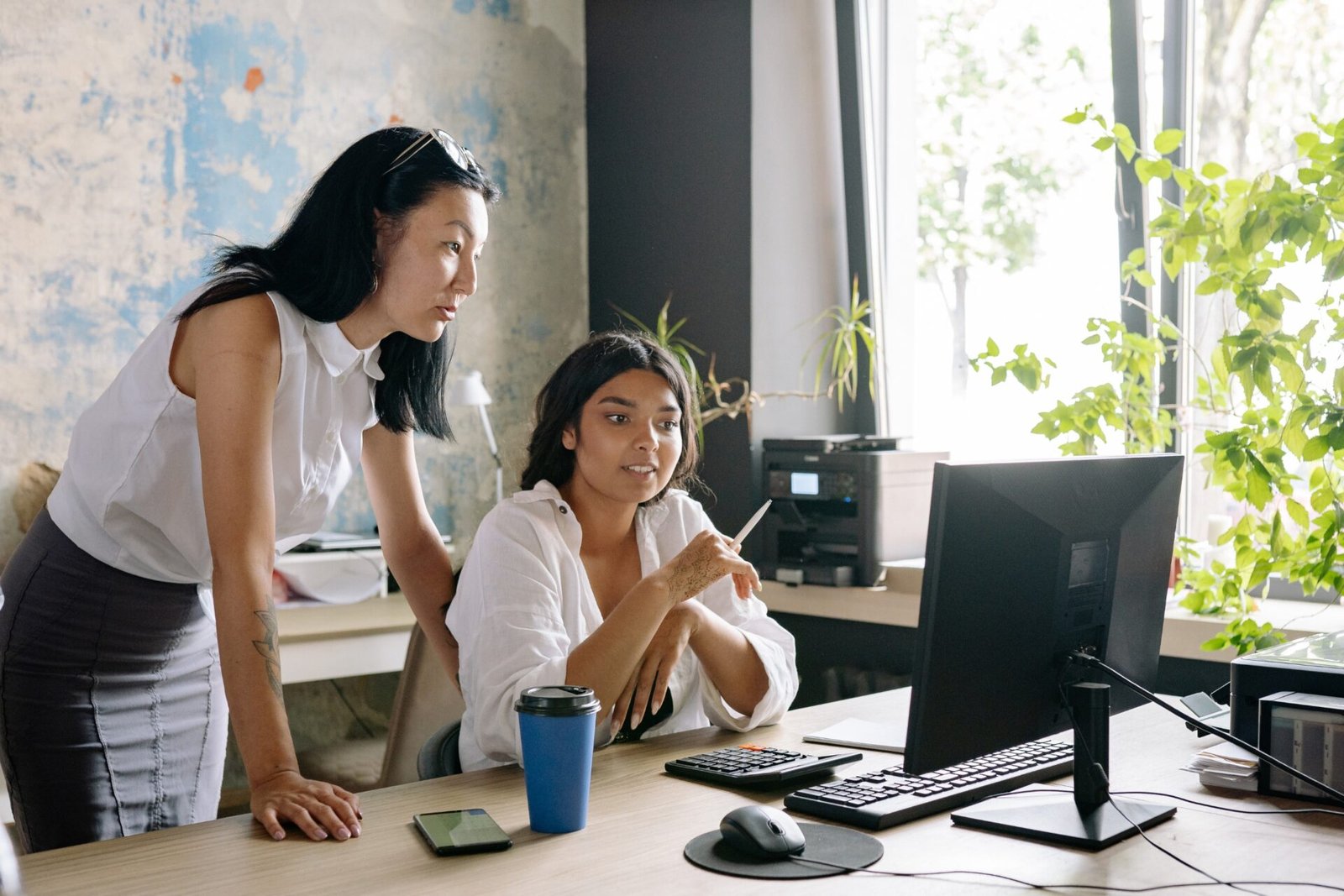 Two women working together in an office, illustrating women's workplace rights, equal pay and career equality in the UK